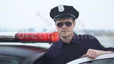 身穿制服、戴墨镜的自信警官站在巡逻车旁